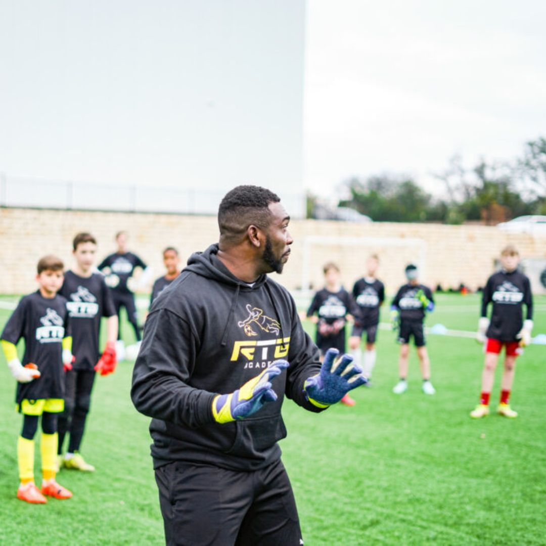 coach demonstrating to players in training