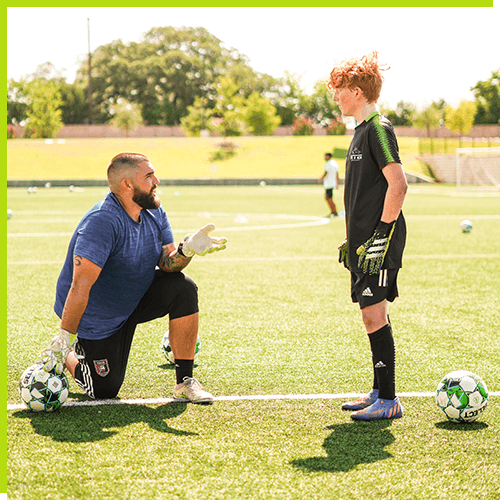 Coach talking with young goalkeeper